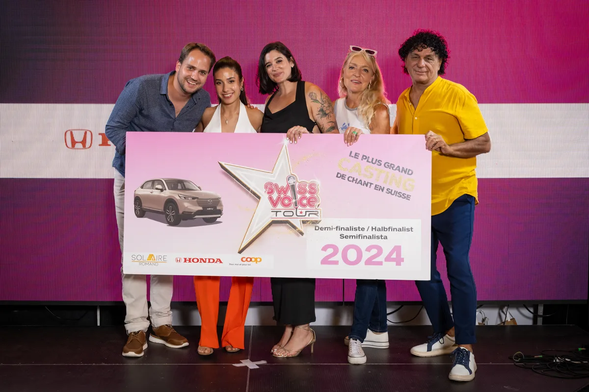 Gewinnerin Elaine Rodriguez Garcia (Mitte) mit Moderator Mario Steiner und den Juroren Elle, Rebecca Spiteri sowie Damiano D’Errico (von links). Fünf Menschen halten ein Plakat in die Luft.